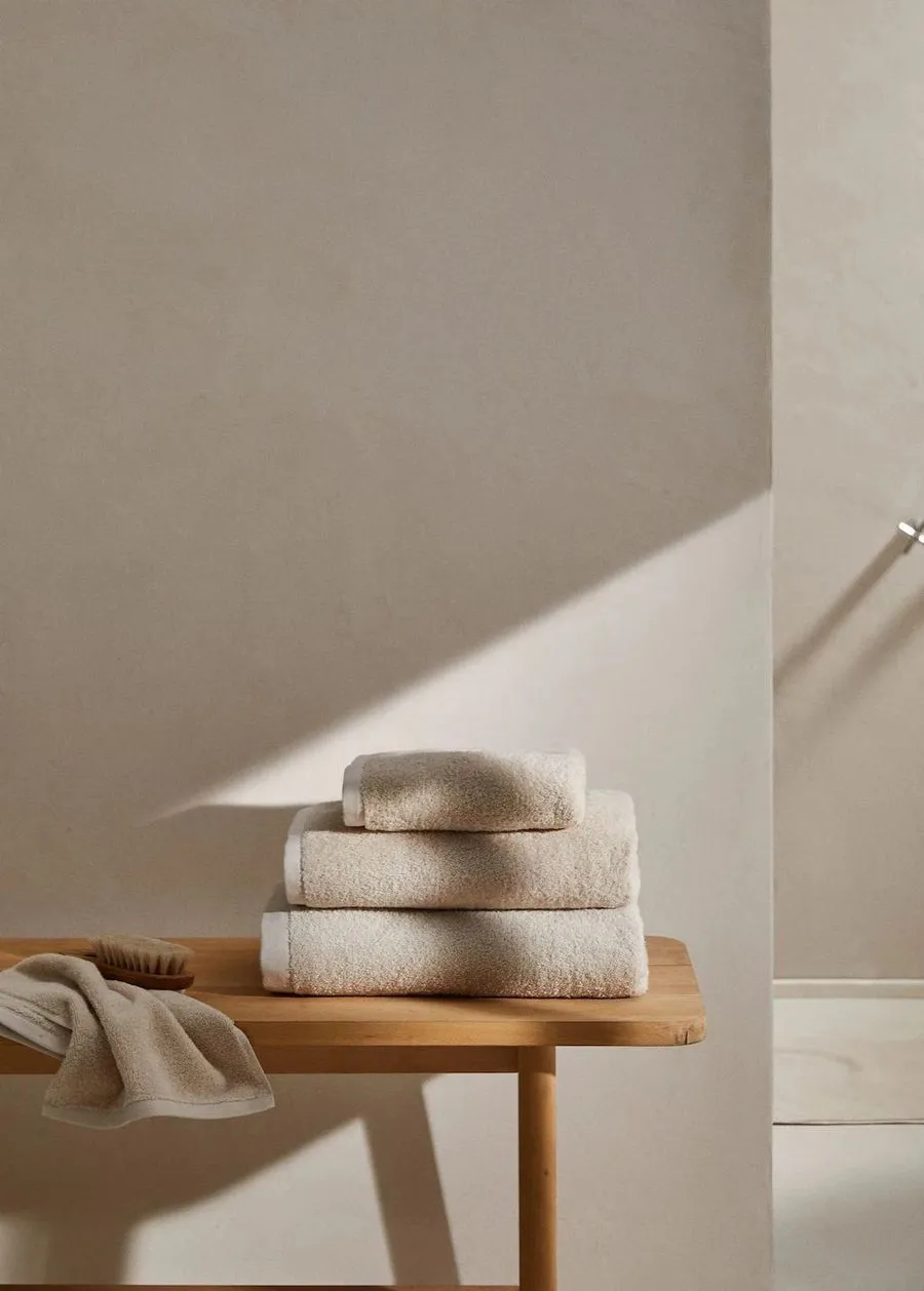 Toallas dobladas sobre banco de madera natural — ritual de spa para Día del Padre en Belgrano