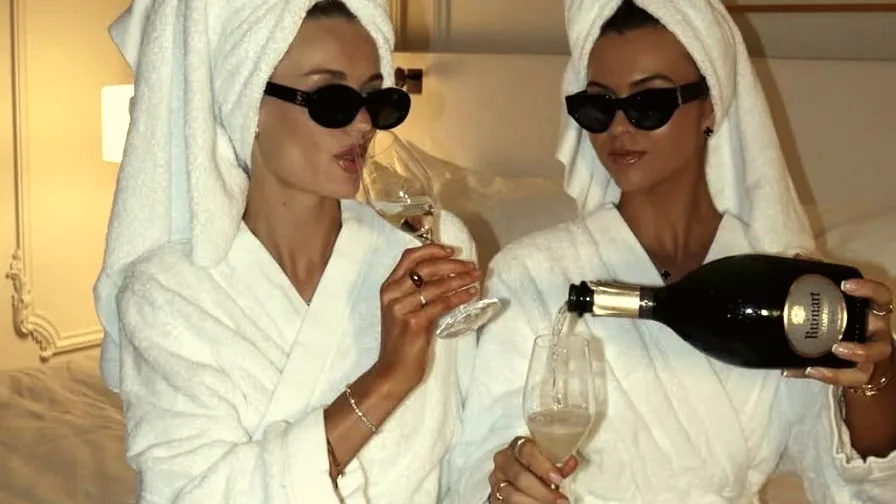 Amigas en batas de spa brindando con champagne durante el Mes del Amigo en Spa Belgrano