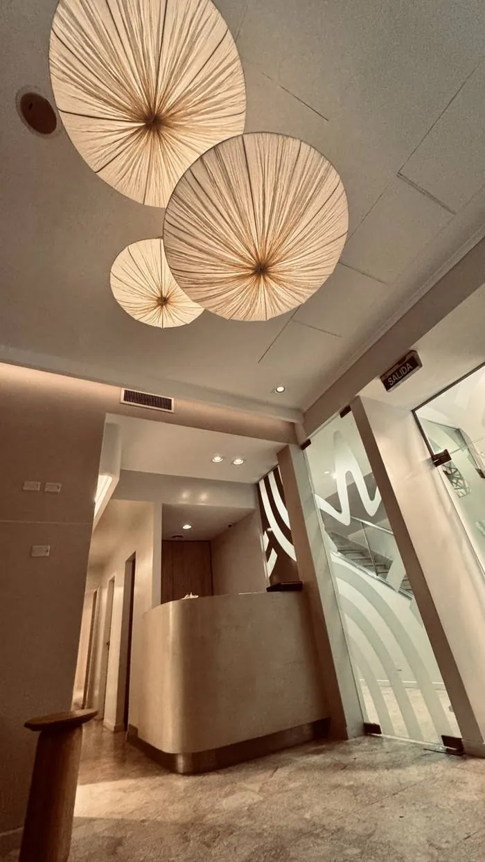 Hall de ingreso de Spa Belgrano con lámparas florales de ratán