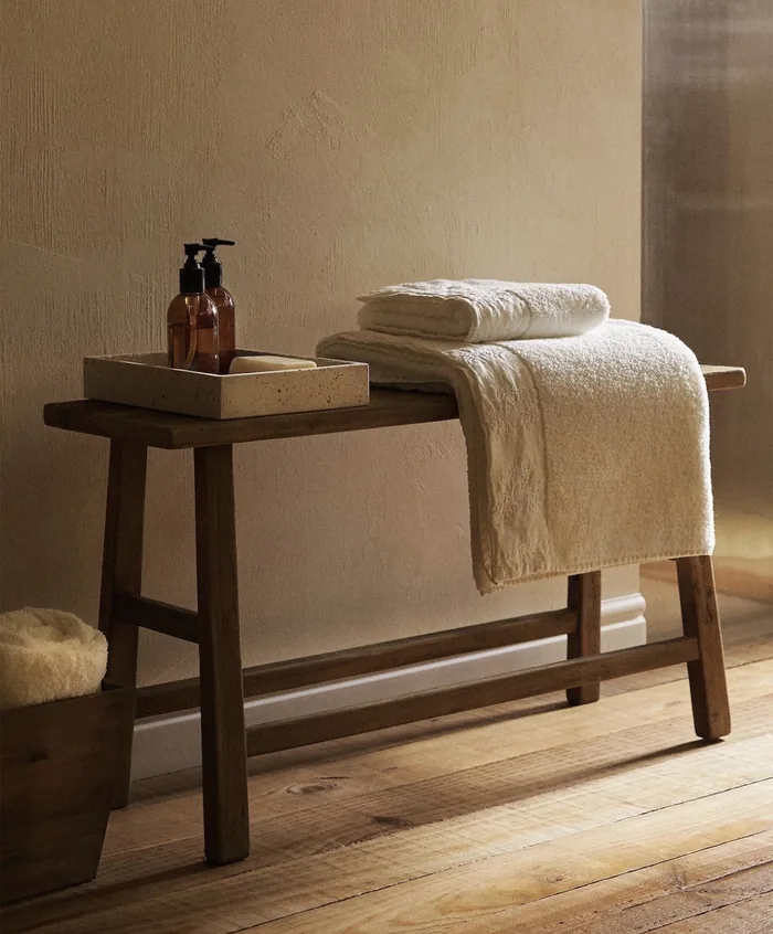 Banco de madera con toallas y amenities de bienestar en Spa Belgrano